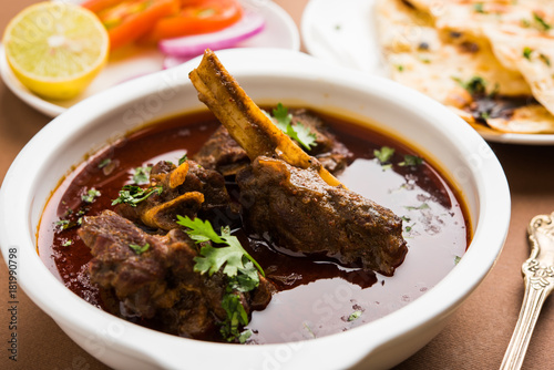 Mutton Masala Or Masala Gosht or indian lamb rogan josh with some seasoning, served with Naan or Roti, selective focus
 photo