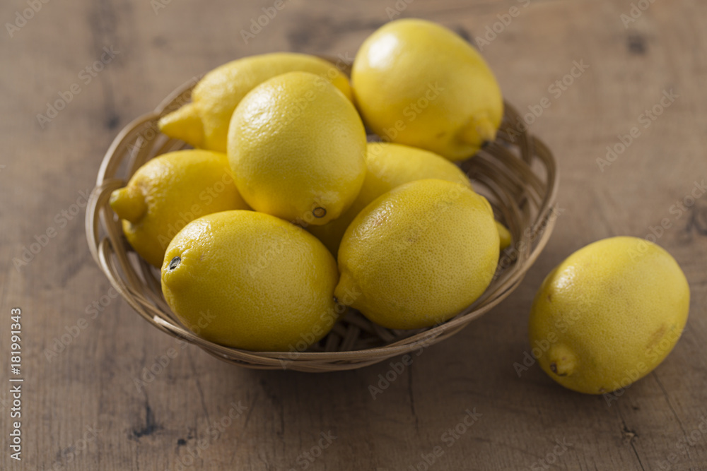 lemons in a basket on wooden surface