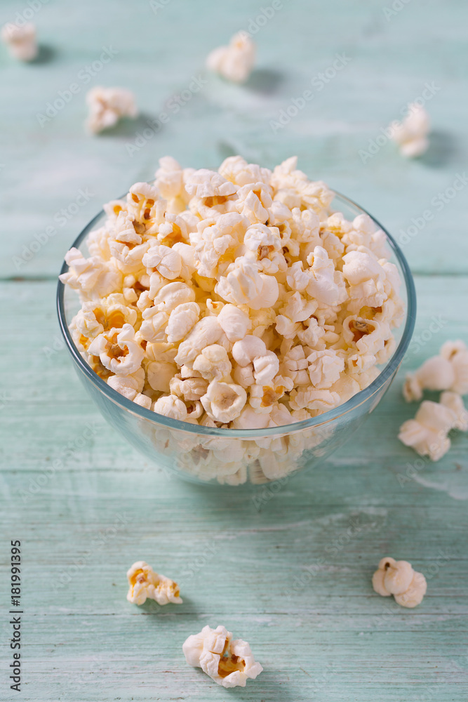salty popcorn on turquoise wooden surface salty popcorn on turquoise wooden surface