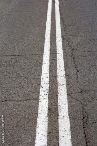 Texture of an asphalt road with a top view of a double white strip