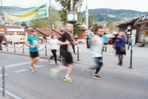 Blurred people running on the street long distance marathon