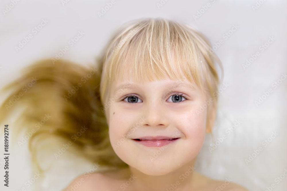 Portrait off cute little blond caucasian kid girl smiling  and  having fun while bathing