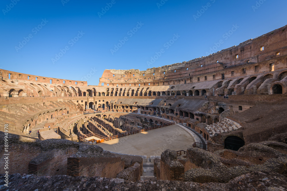 The central oval arena of the ancient roman coliseum, Rome, Italy, with tiered terraces, at sunrise.