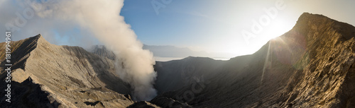 Panorama of Gunung Bromo inner volcano crater, with sulphur fumes and mist at sunrise, in Java, Indonesia.