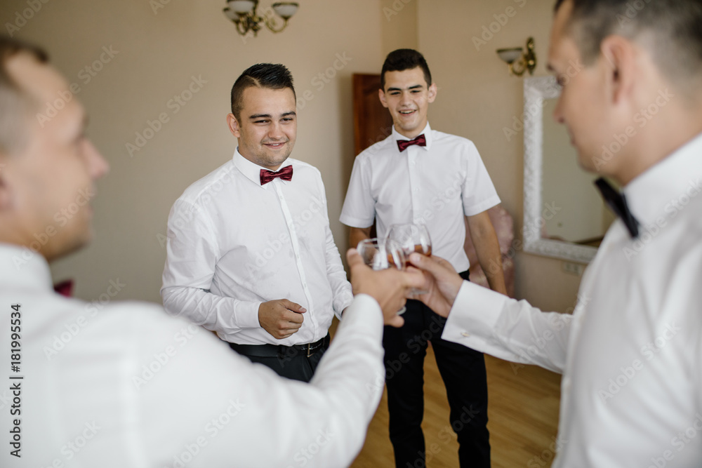 Obraz premium Handsome groom preparing for wedding ceremony in hotel room