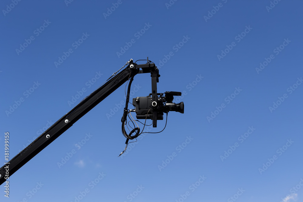 Professional Video Camera Attached To Jib Against Blue Sky Professional Video Camera Attached To Jib Against Blue Sky
