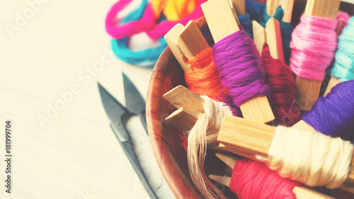 Colorful thread on wood workplace background, selective focus and vintage color tone process