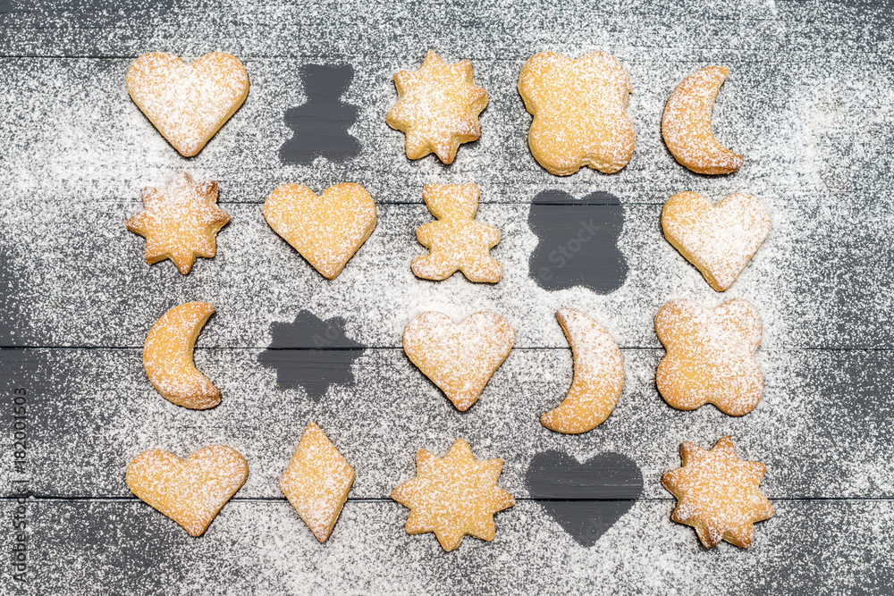 Christmas different shaped cookies with sugar powder on dark wooden table Christmas different shaped cookies with sugar powder on dark wooden table