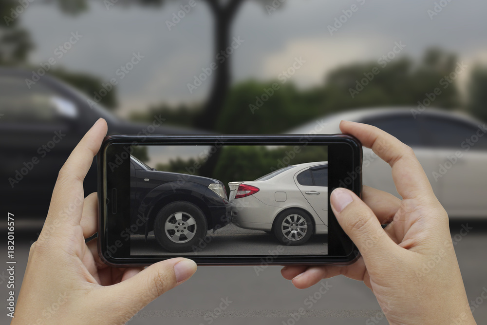 Hand holding smart phone take a photo at The scene of a car crash, car accident for insurance