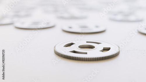 chrome gears scattered on a white surface with shallow depth of field