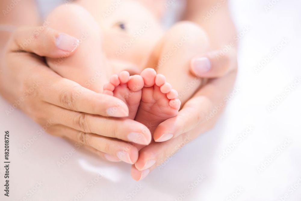 Parent holding in the feet of newborn baby.