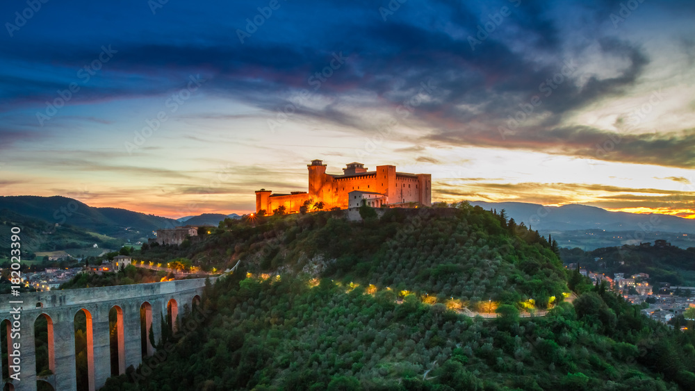 Stunning sunset over the highlighted castle in Spoleto, Italy
