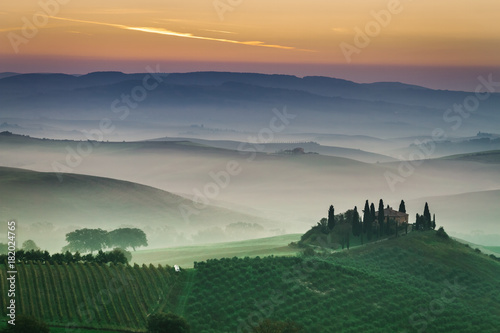 Stunning foggy green fields at sunset in Tuscany  Italy
