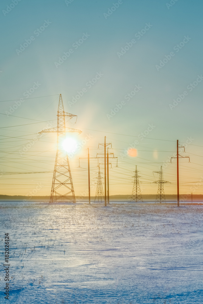 Winter field with supports during sunset