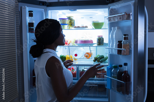 Woman Taking Out Bottle From Refrigerator
