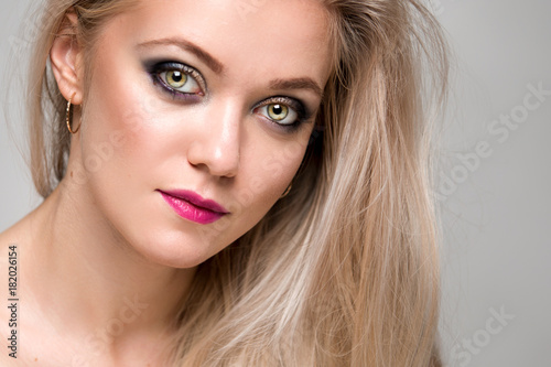 Portrait of a beautiful young woman with luxurious blond hair. Female face close-up. Makeup