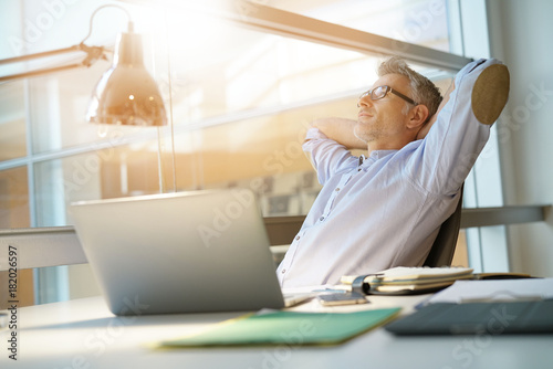 Businessman in office relaxing in chair