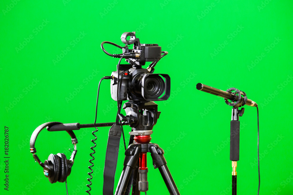 Video camera on a tripod, headphones and a directional microphone on a green  background. The chroma key. Green screen. Stock Photo | Adobe Stock
