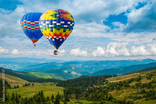 Colorful hot-air balloons flying over the mountains. Artistic picture. Beauty world.