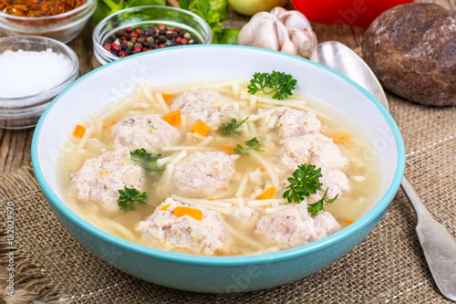 Soup with meatballs for dinner on wooden background