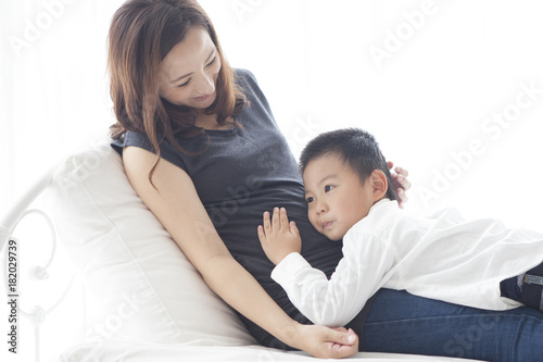 Boy listening to the sound of mother's stomach