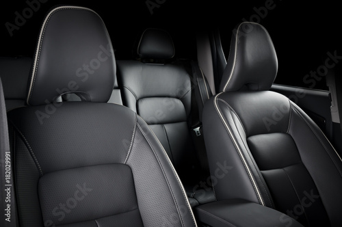 Luxury car inside. Interior of prestige modern car. Comfortable leather seats. Black perforarated leather cockpit.