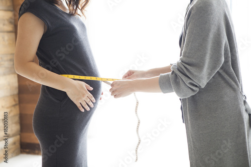 Pregnant woman measuring stomach size