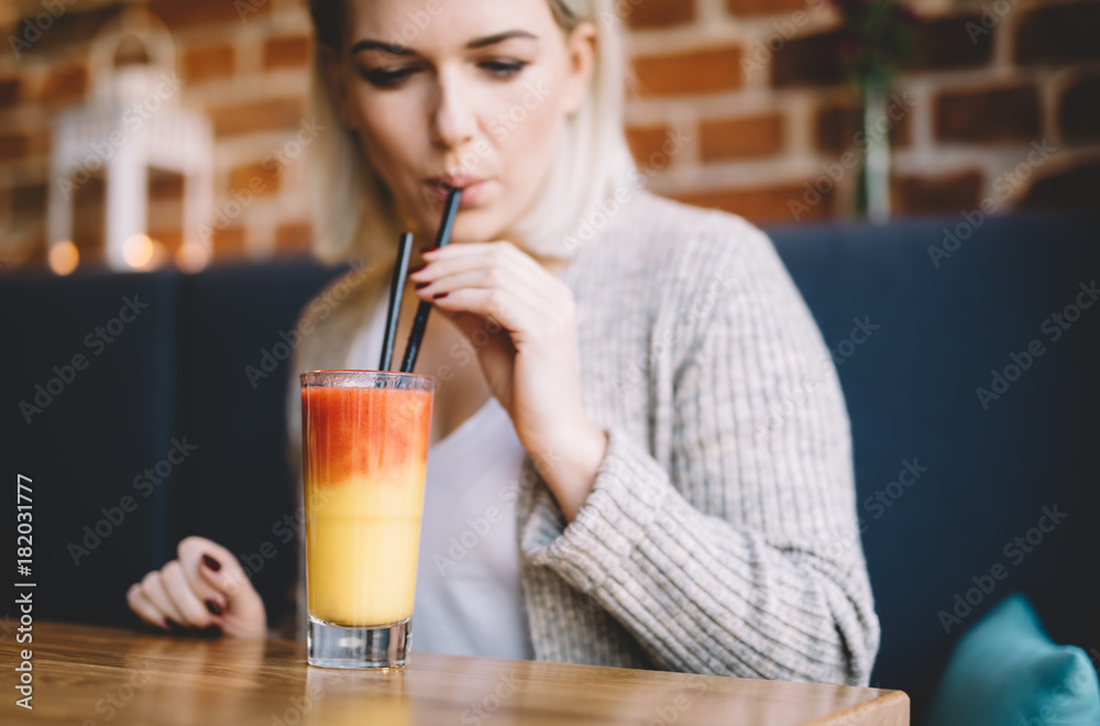 Young woman sipping a healthy smoothie in a restaurant. Young woman sipping a healthy smoothie in a restaurant.