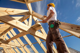 roofer builder working on roog structure of building on construction site
