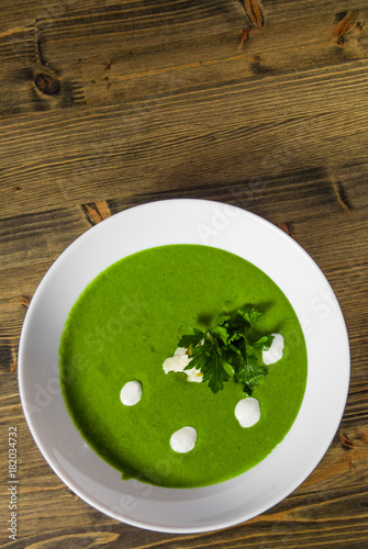 Spinach cream soup in bowl on a wooden background. with copy space. top view