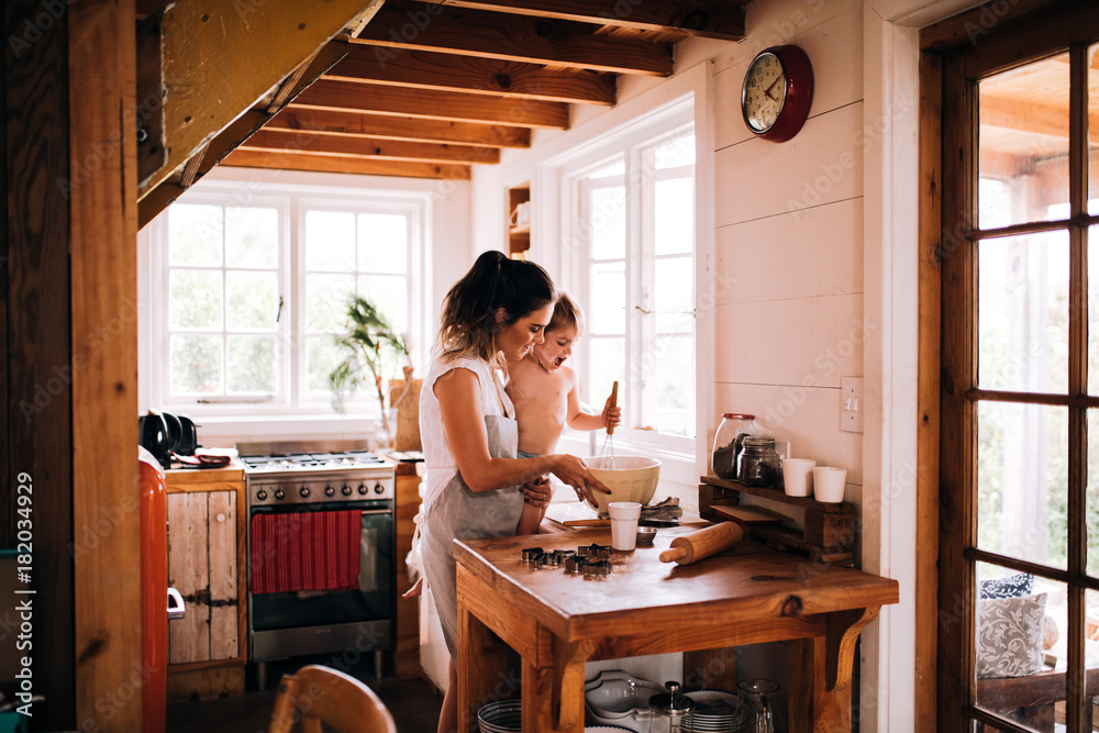 Caucasian mother and son baking cookies in kitchen together Caucasian mother and son baking cookies in kitchen together