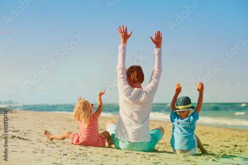 happy father and kids play on beach