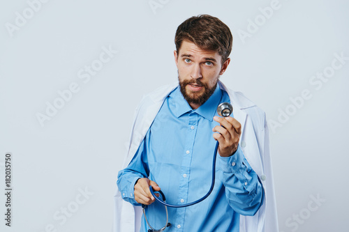 Male doctor with stethoscope on a light background