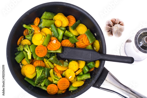 Stewed vegetables in frying pan over white background