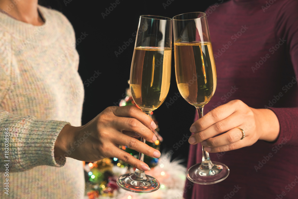 Beautiful two women holding glasses with champagne celebrating Christmas and gift boxes at corporate party and christmas lights, New Year Frame for your text