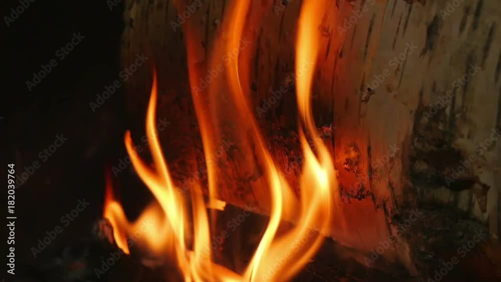 Beautiful warm orange flames comming out of birch burning logs. Logs slowly burn in inside open fireplace in slow motion hd. Beautiful warm orange flames comming out of birch burning logs. Logs slowly burn in inside open fireplace in slow motion hd.