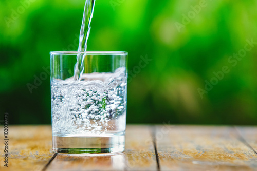 A glass of water on green background
