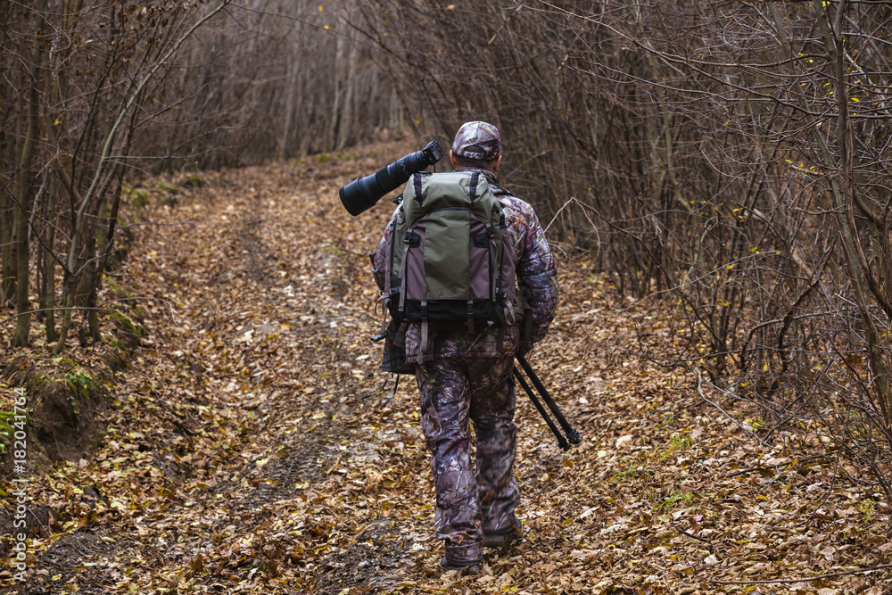 professional photographer with camouflage outfit in nature