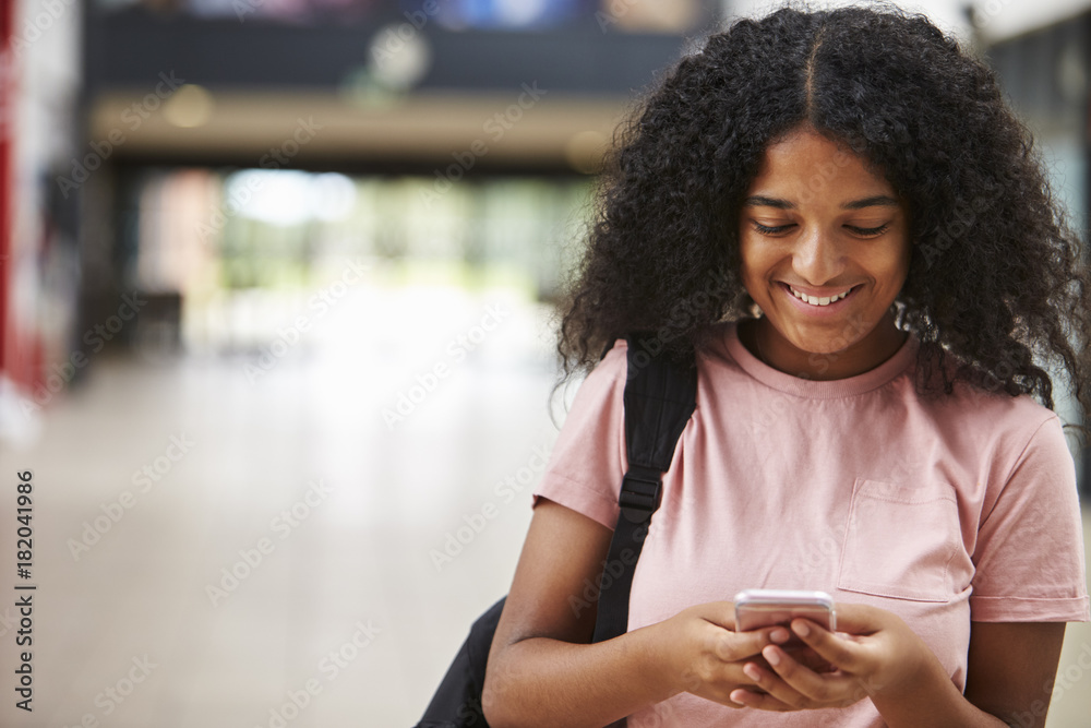 Female College Student Reading Text Message On Mobile Phone Female College Student Reading Text Message On Mobile Phone