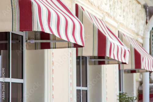 Tents and windows of a city cafe. Red and white stripes photo