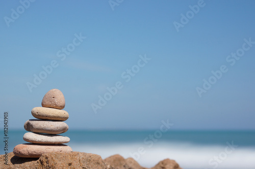 Pyramid of stones on the shore of the blue sea  harmony
