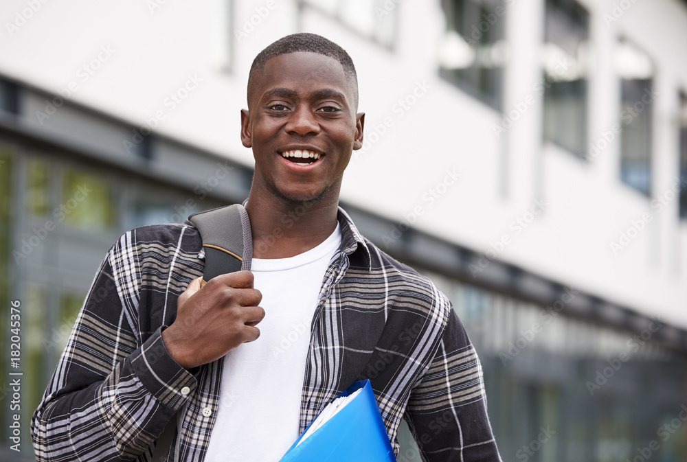© Monkey Business - Portrait Of Male Student Standing Outside College Building