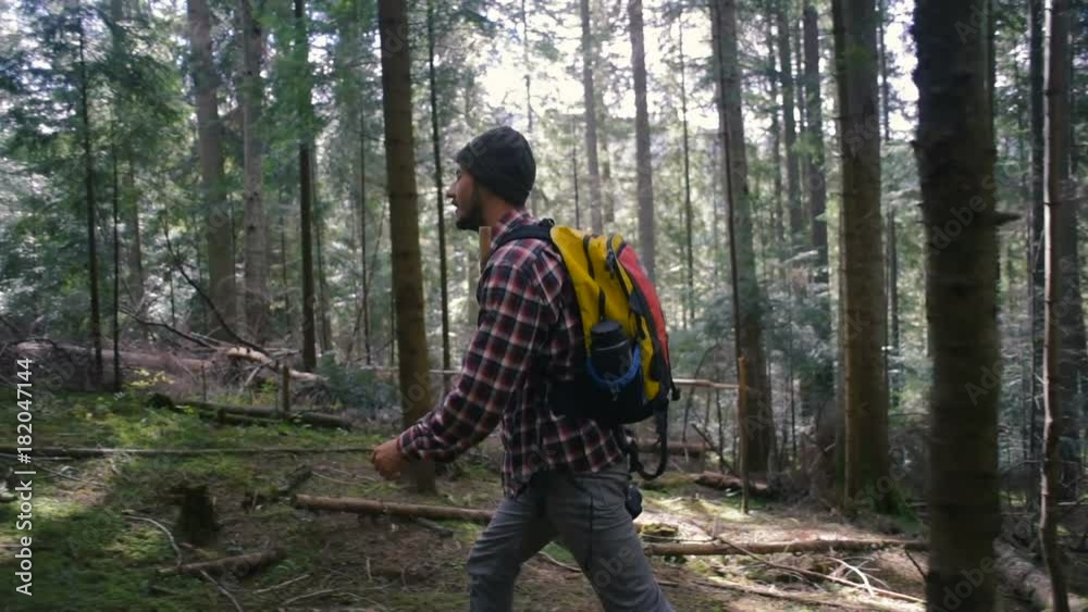 man hiking in the forest with backpack