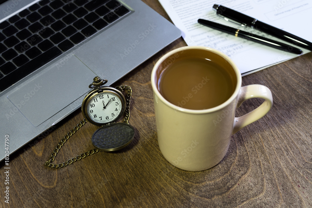 Coffee break! Home office interior in loft space. Workplace with wooden table, office supplies, documents, organizer and laptop. Modern office workplace. Coffee break! Home office interior in loft space. Workplace with wooden table, office supplies, documents, organizer and laptop. Modern office workplace.