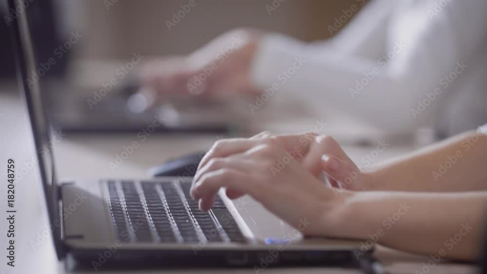 Close up shot of worker typing on a laptop Close up shot of worker typing on a laptop