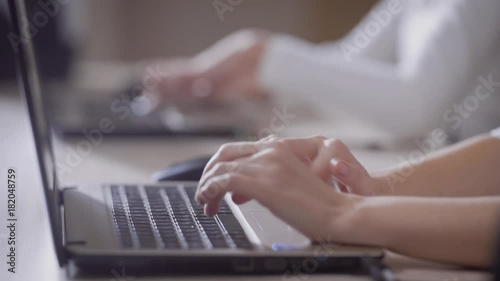 Close up shot of worker typing on a laptop photo