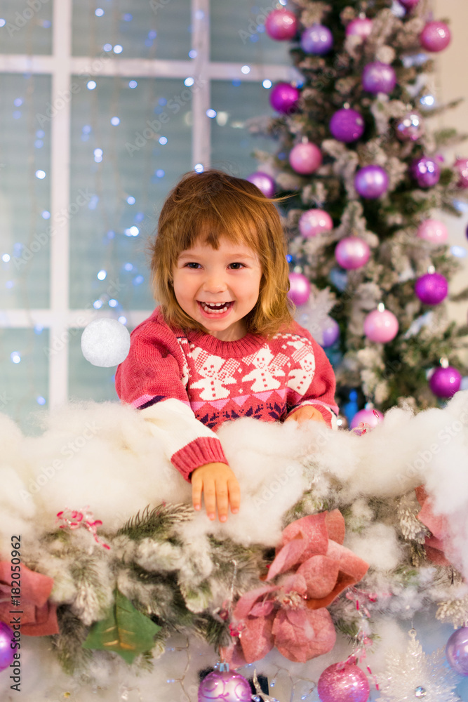 Happy baby girl playing with snowballs in the room. The girl throws a snowball. Happy baby girl playing with snowballs in the room. The girl throws a snowball.