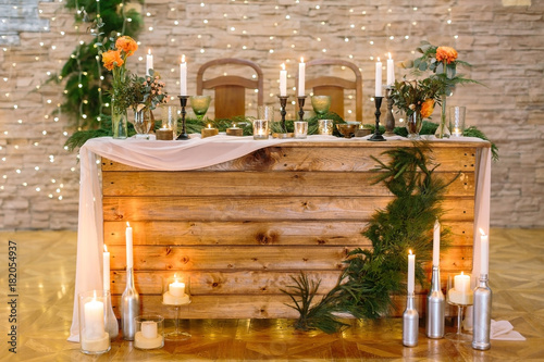 interior, holidays, engagement concept. furniture made of natural materials, used for celebration of wedding in the restaurant, it is surved for couple of lover and decorated with plants and candles photo