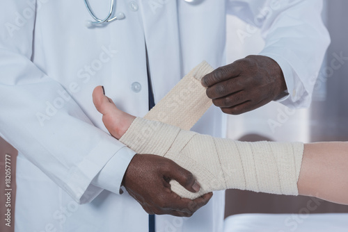 doctor bandaging patient leg