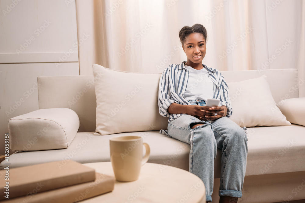 woman on couch using smartphone